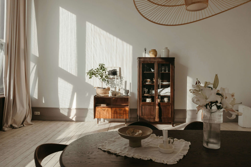Bright living room with wooden furniture, plant, and floral centerpiece showcasing small decor changes for a positive impact.