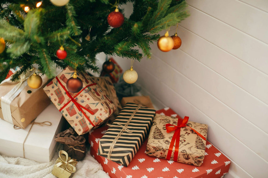 Christmas gifts beautifully wrapped under a festive tree, creating a warm holiday atmosphere.