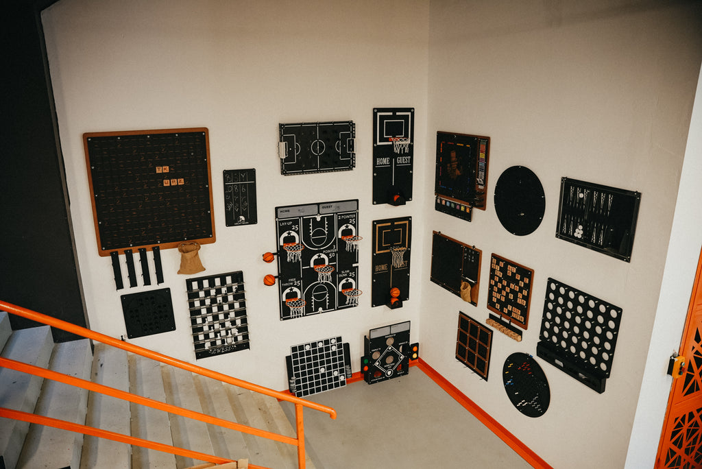 Creative wall art featuring various game boards and designs in a modern stairwell.