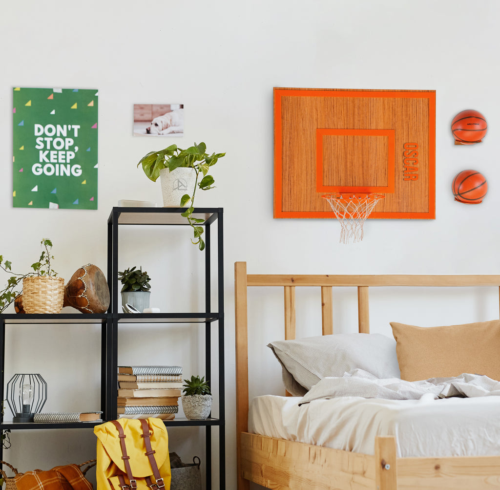 Wooden basketball hoop on a bedroom wall, featuring vibrant decor and organized workspace for a playful atmosphere.
